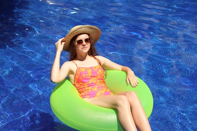 Photo of Girl on inflatable ring in swimming pool outdoors on sunny day