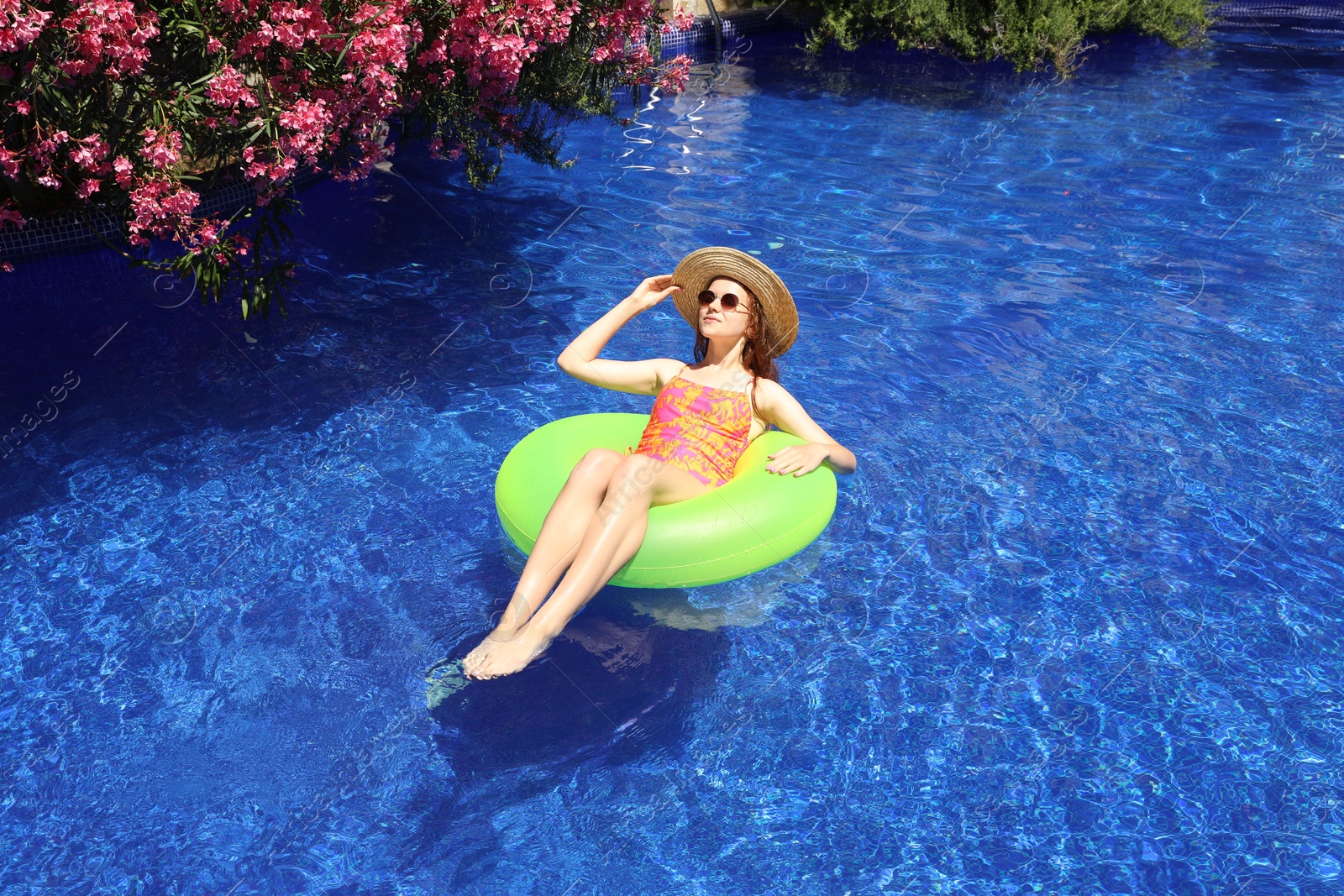 Girl on inflatable ring in swimming pool outdoors on sunny day Photo of Girl on inflatable ring in swimming pool outdoors on sunny day