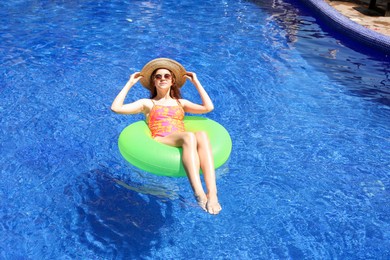 Photo of Girl on inflatable ring in swimming pool outdoors on sunny day