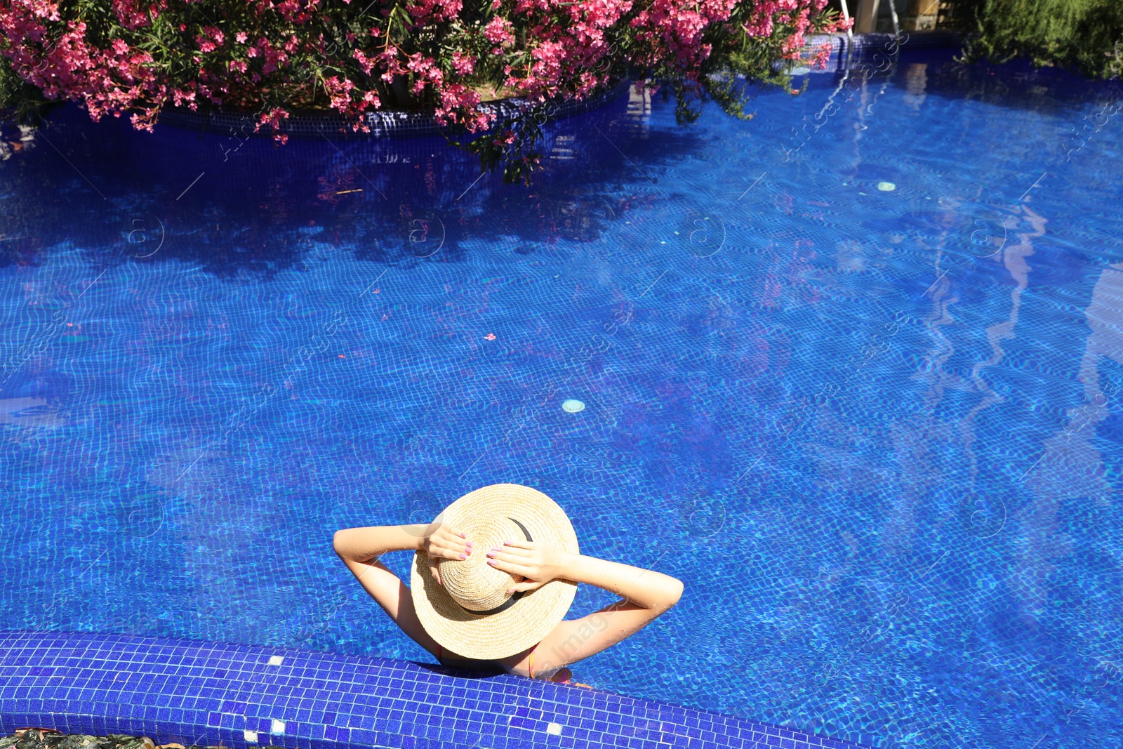 Girl with straw hat in swimming pool outdoors on sunny day, above view Photo of Girl with straw hat in swimming pool outdoors on sunny day, above view