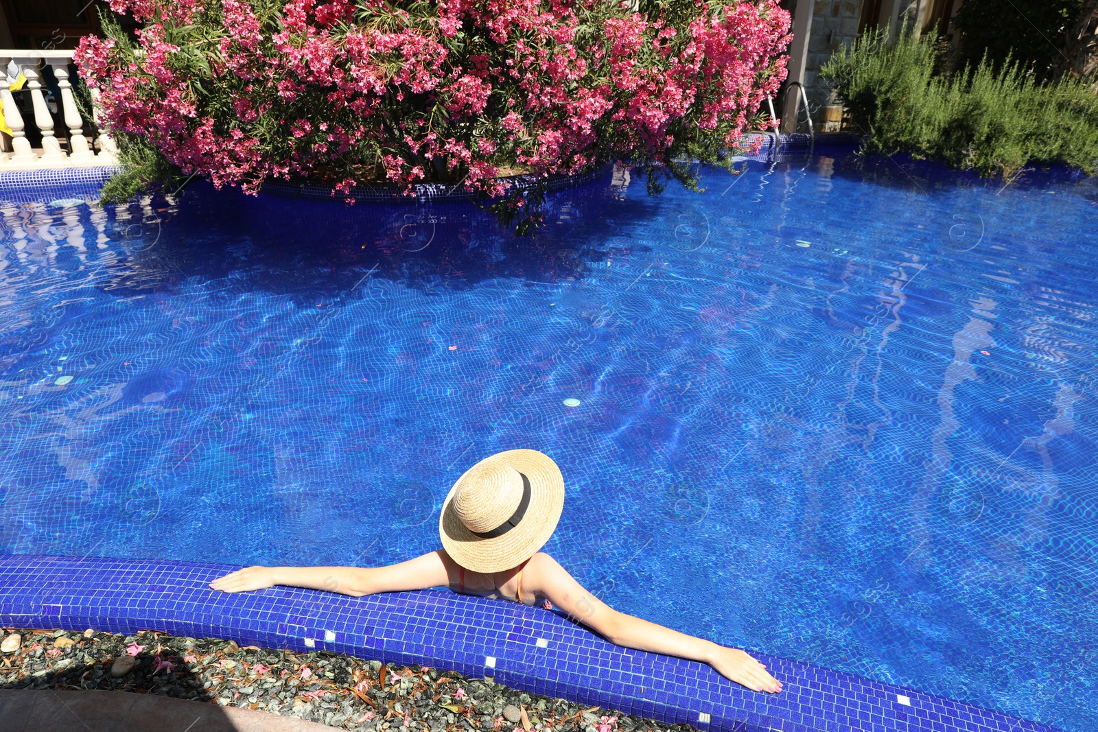 Girl with straw hat in swimming pool outdoors on sunny day, above view Photo of Girl with straw hat in swimming pool outdoors on sunny day, above view