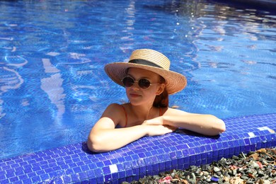 Photo of Girl with straw hat in swimming pool outdoors on sunny day