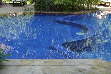 Photo of Outdoor swimming pool with clear water and green plants