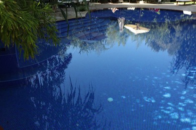 Photo of Outdoor swimming pool with clear water and green plant