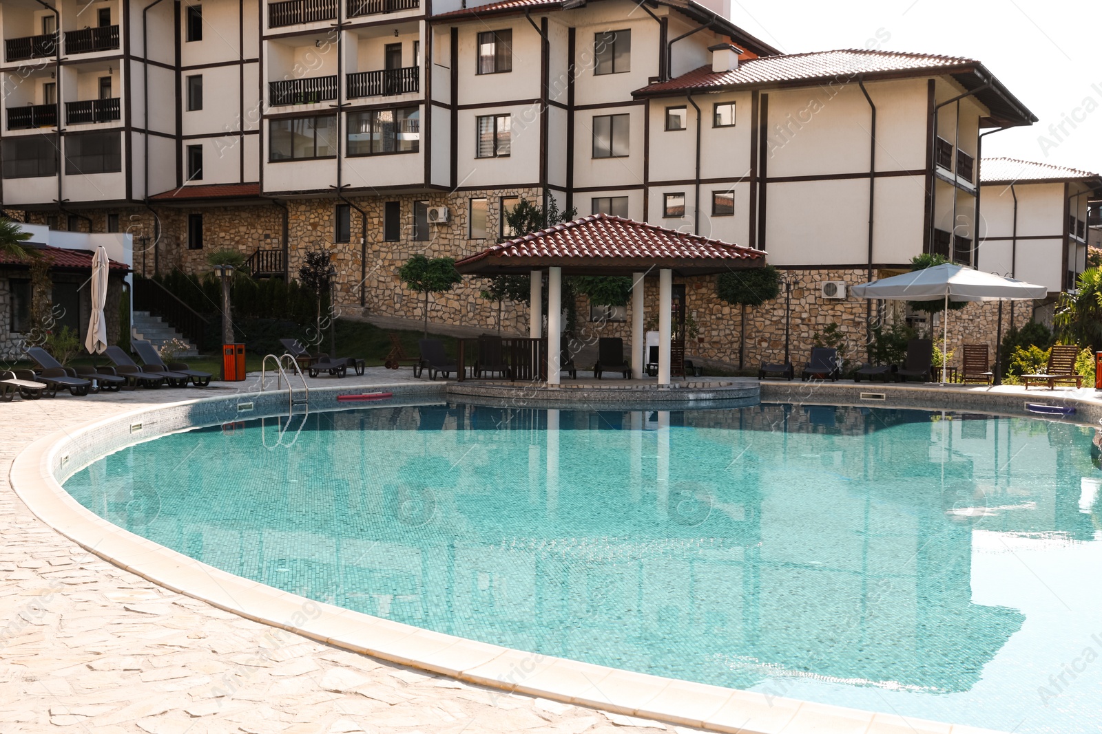 Photo of Outdoor swimming pool and sunbeds near hotel at luxury resort