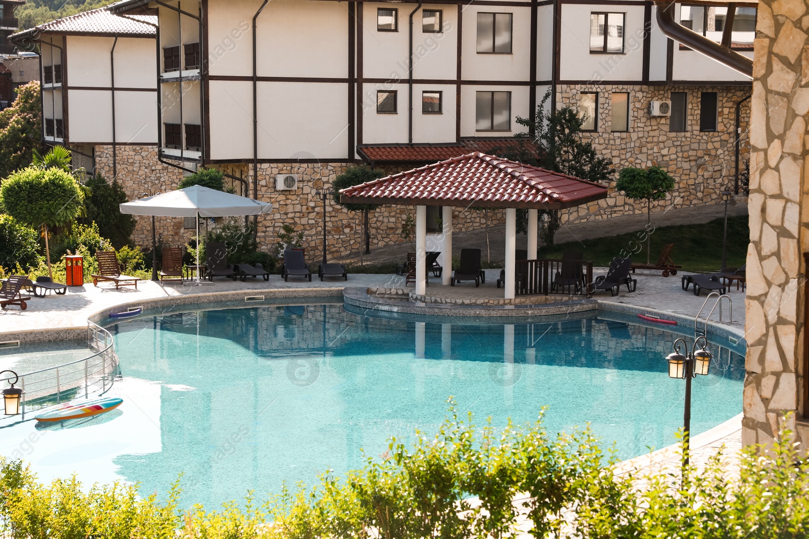 Photo of Outdoor swimming pool and sunbeds near hotel at luxury resort