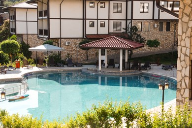 Photo of Outdoor swimming pool and sunbeds near hotel at luxury resort