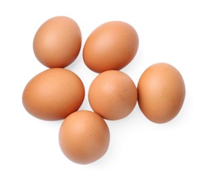 Photo of Many raw chicken eggs isolated on white, top view