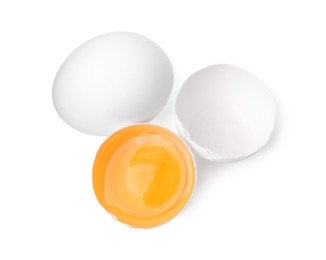 Photo of Whole and broken chicken eggs isolated on white, top view