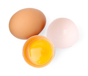 Photo of Whole and broken chicken eggs isolated on white, top view