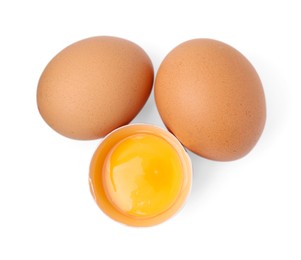 Photo of Whole and broken chicken eggs isolated on white, top view