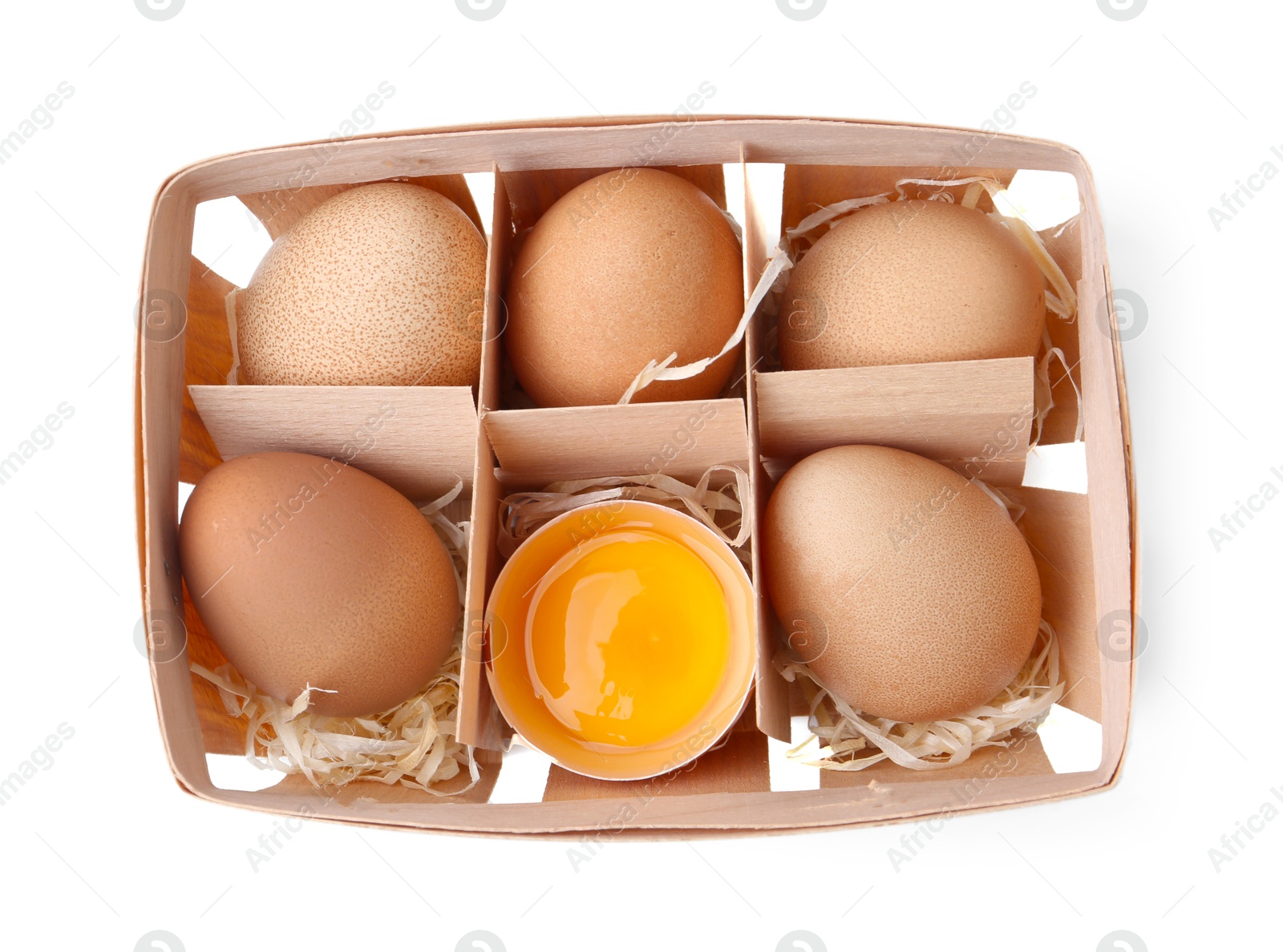 Whole and broken chicken eggs in wooden tray isolated on white, top view Photo of Whole and broken chicken eggs in wooden tray isolated on white, top view