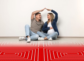 Image of Pregnant woman with her husband making roof with their hands while sitting on warm floor indoors. Illustration of underfloor heating on floor