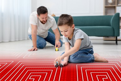Image of Father and son feeling comfortable to play on warm floor at home. Illustration of underfloor heating system
