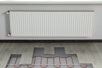 Image of Underfloor heating system installed in room. Pipes seen under laminate