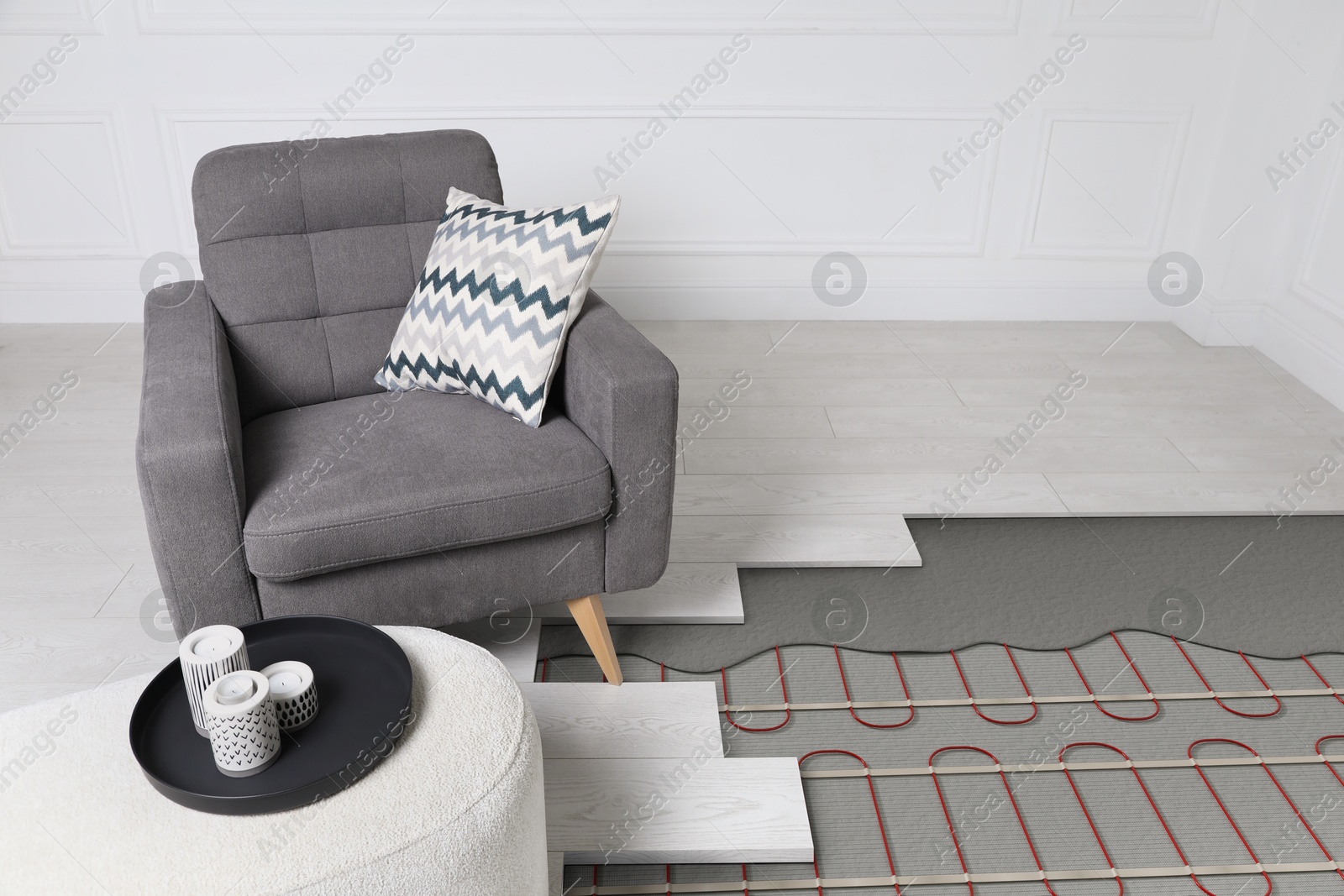 Underfloor heating system installed in room with armchair and pouf. Pipes seen under laminate Image of Underfloor heating system installed in room with armchair and pouf. Pipes seen under laminate