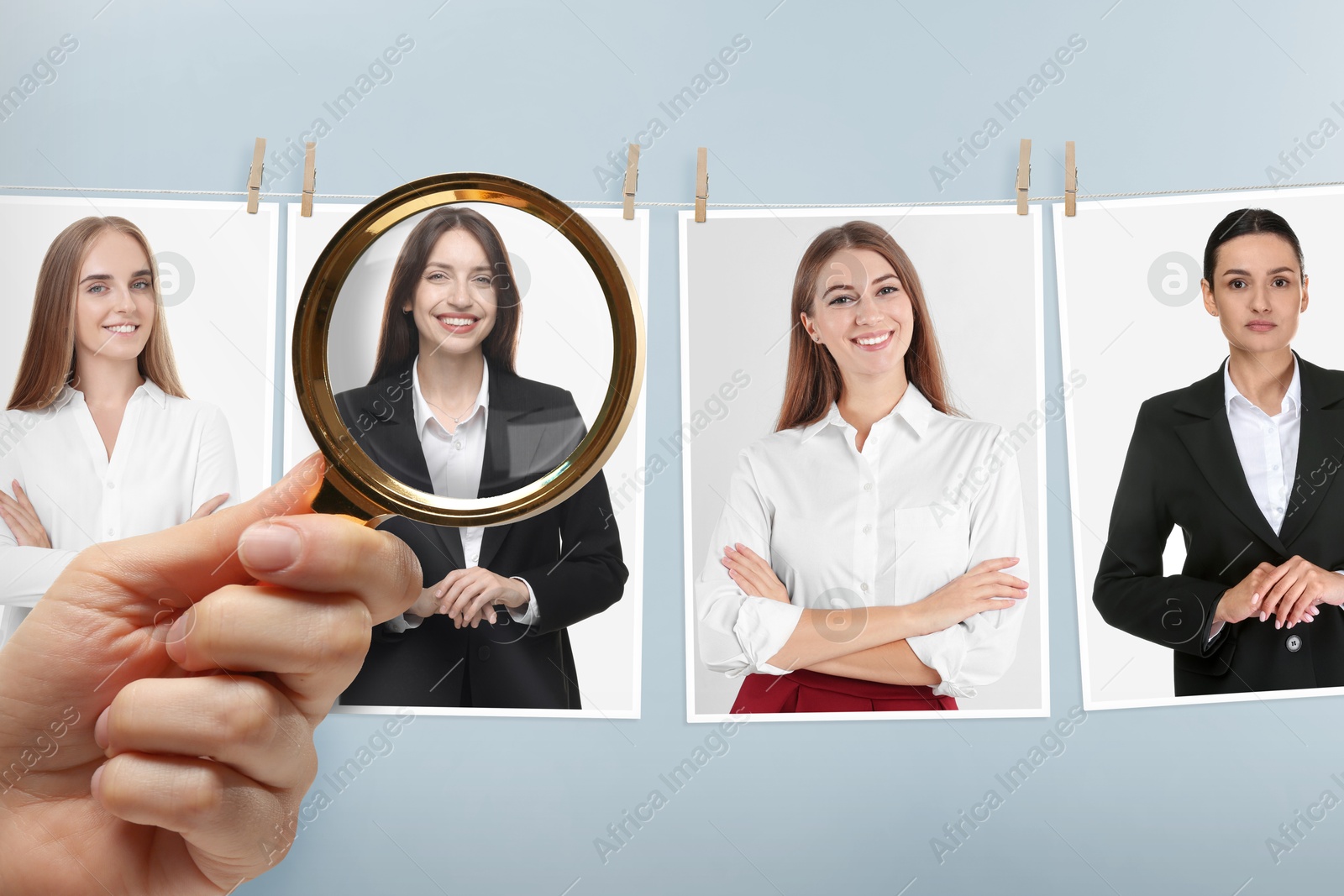Image of Recruiter looking at candidate's photo through magnifying glass against grey background, closeup. Human resources management