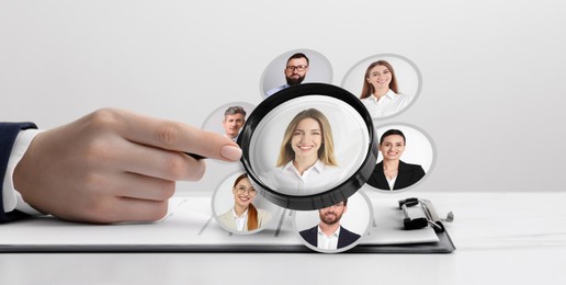Image of Recruiter looking at candidate's photo through magnifying glass at table, closeup. Human resources management