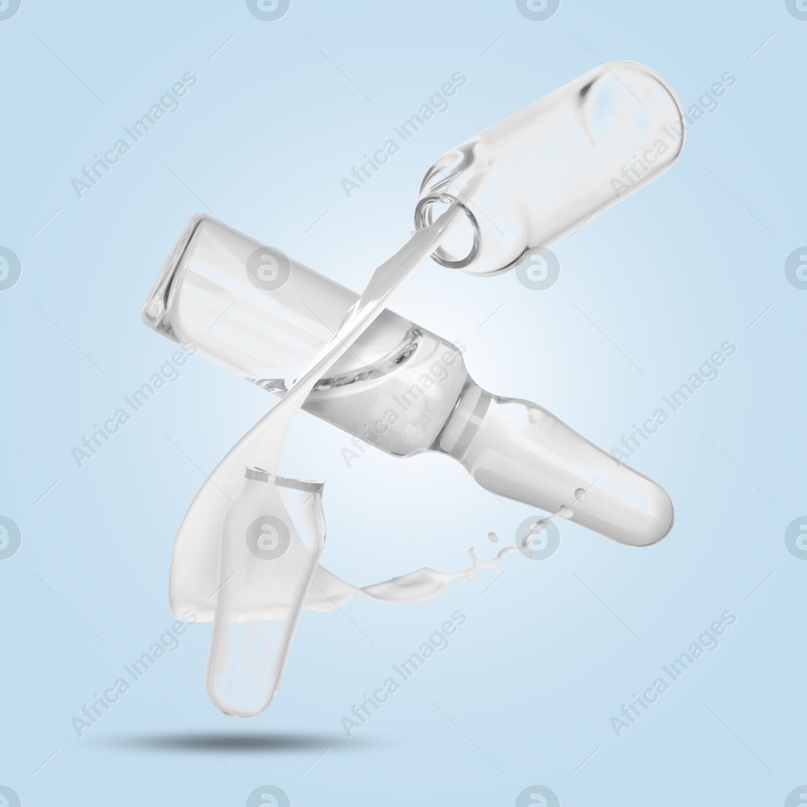 Image of Ampoules and splash of medical or cosmetic liquid in air against light blue background