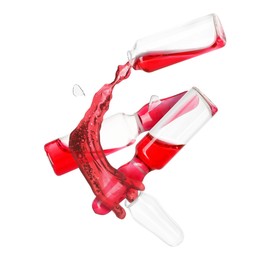 Image of Ampoules and splash of medical or cosmetic liquid in air against white background