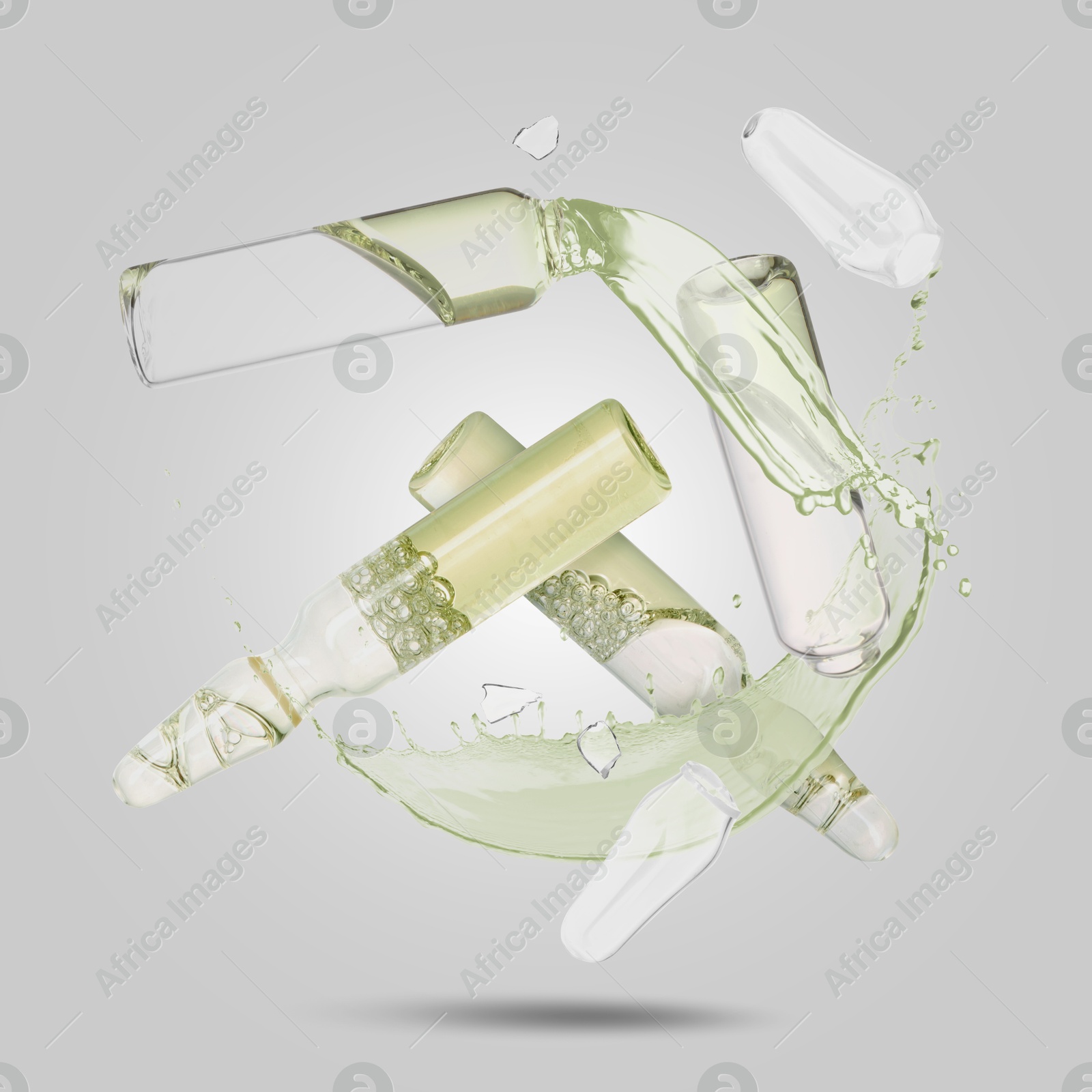 Image of Ampoules and splash of medical or cosmetic liquid in air against grey background
