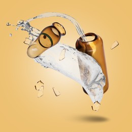 Image of Broken ampoule and splash of medical or cosmetic liquid in air against pale orange background