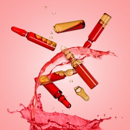 Image of Ampoules and splash of medical or cosmetic liquid in air against pink background