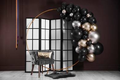 Photo of Stylish photo zone with balloons, armchair and decor in studio