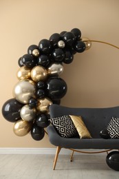 Photo of Stylish photo zone with balloons and sofa near beige wall