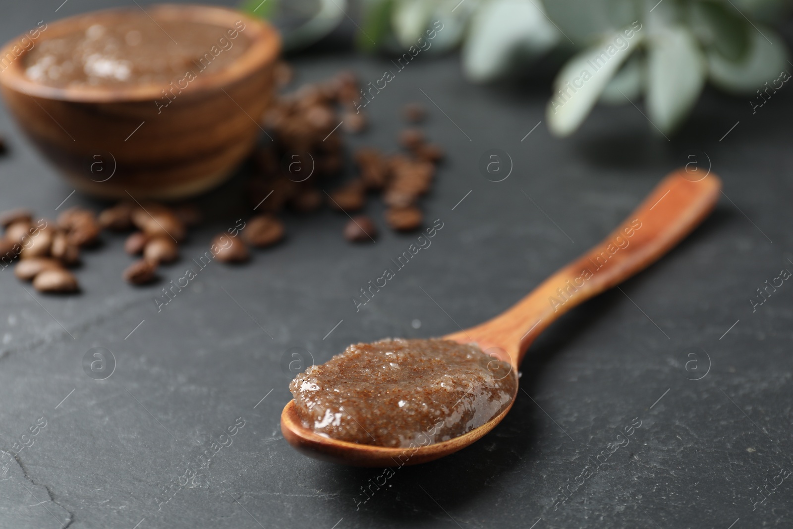 Natural body scrub and coffee beans on black table, closeup Photo of Natural body scrub and coffee beans on black table, closeup