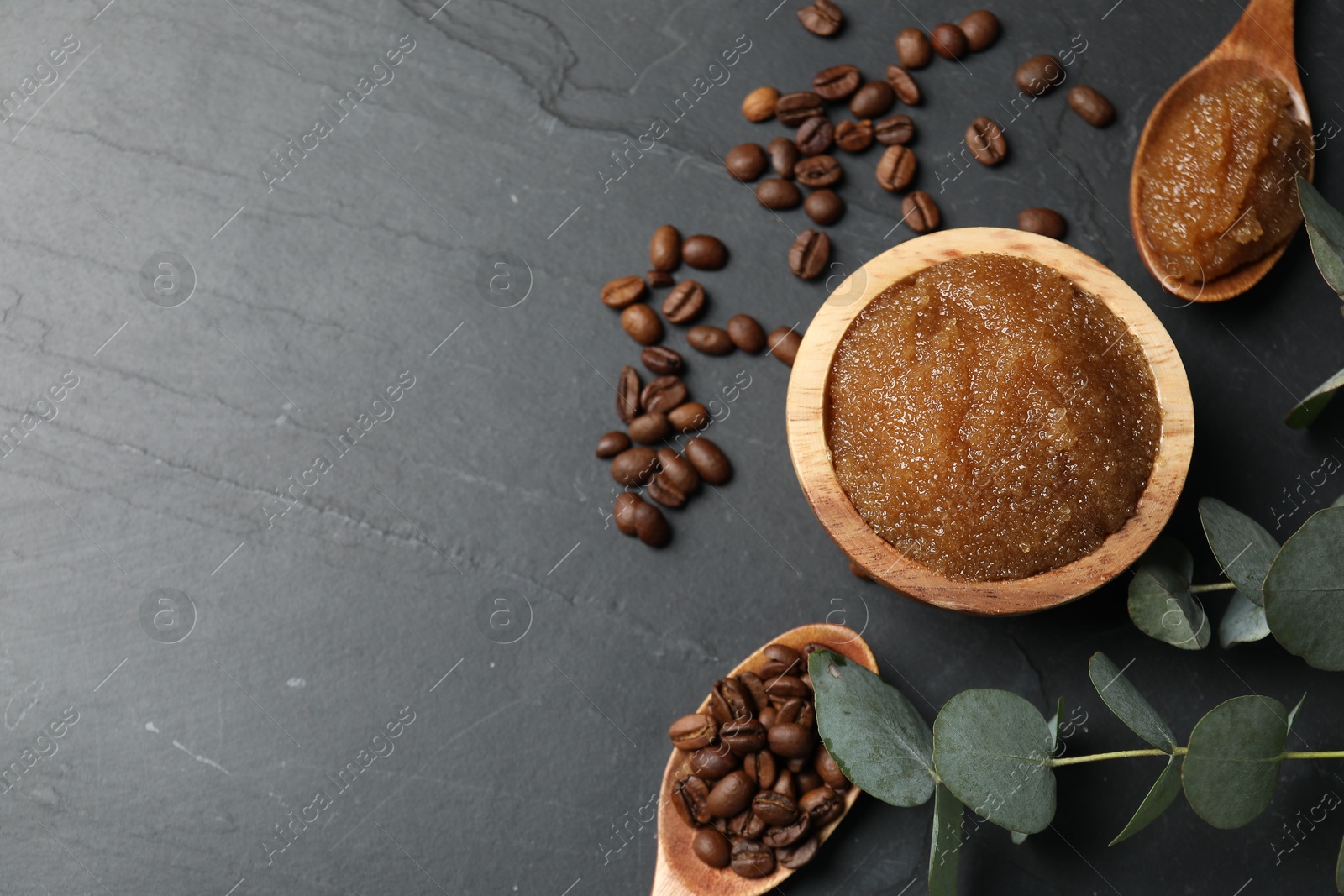 Natural body scrub, coffee beans and eucalyptus leaves on black table, flat lay. Space for text Photo of Natural body scrub, coffee beans and eucalyptus leaves on black table, flat lay. Space for text