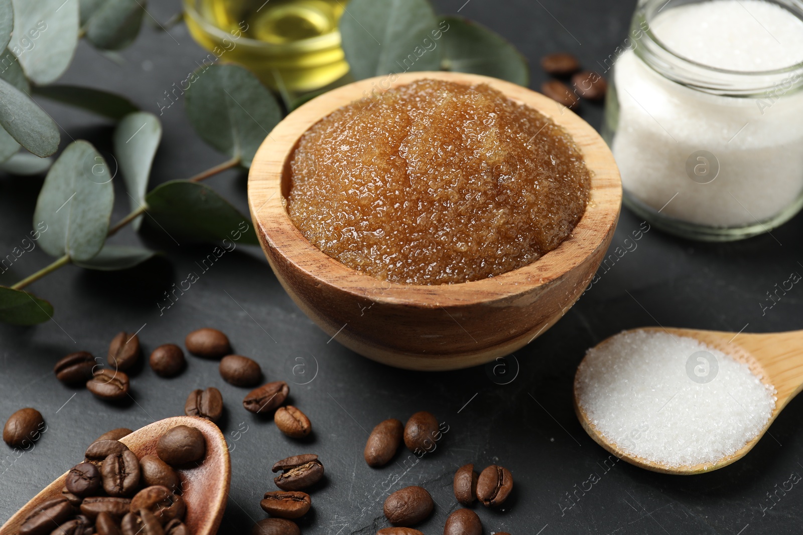Natural body scrub and ingredients on black table, closeup Photo of Natural body scrub and ingredients on black table, closeup