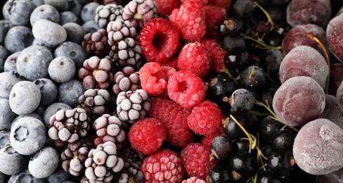 Photo of Many different frozen berries as background, top view