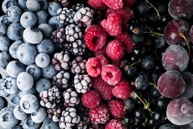 Photo of Many different frozen berries as background, top view