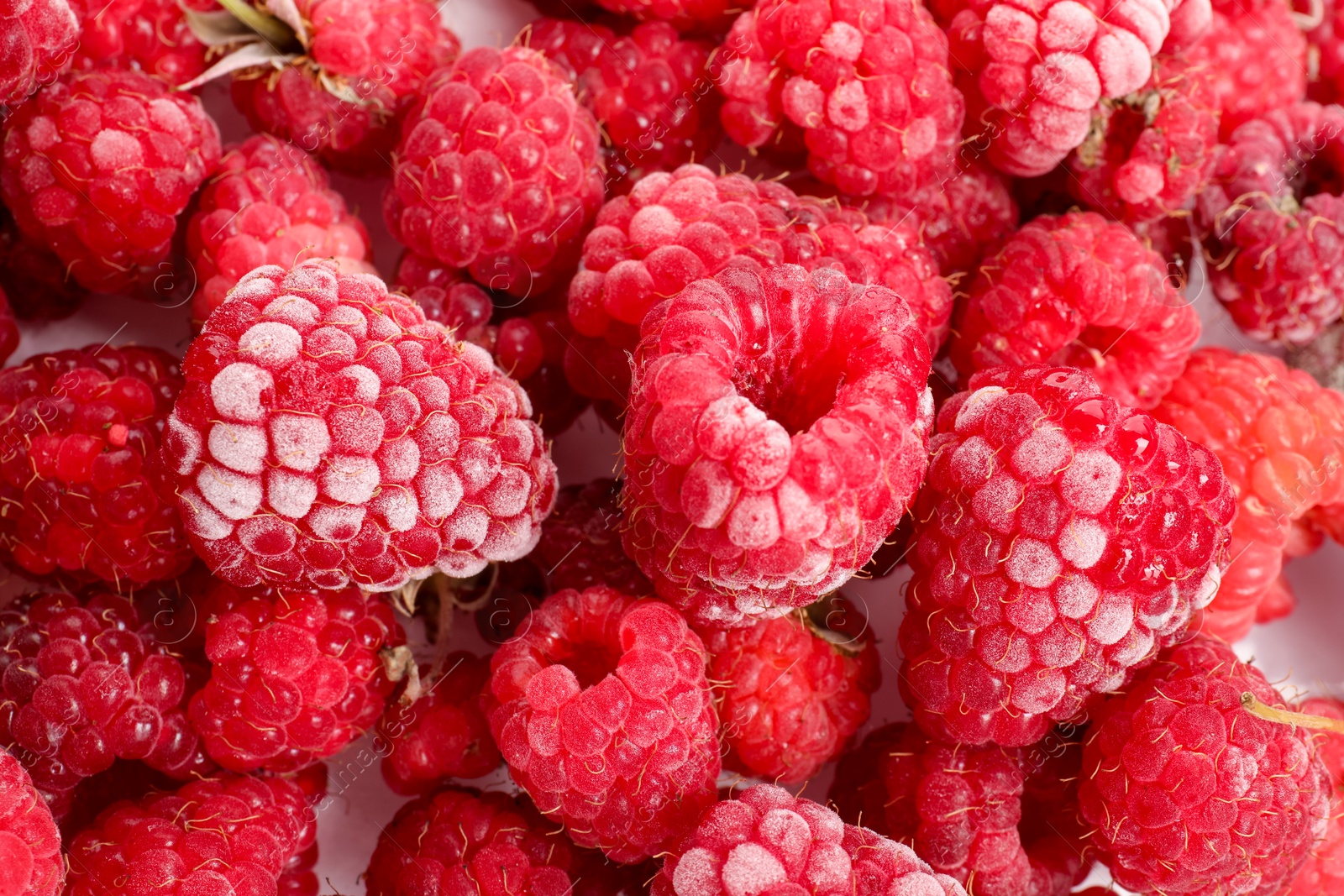 Photo of Many frozen raspberries on table, top view