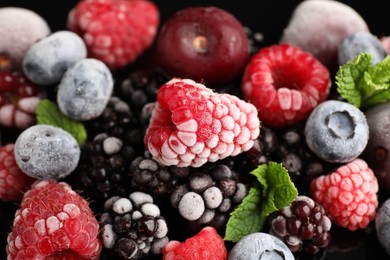 Photo of Many different frozen berries and mint on table, closeup