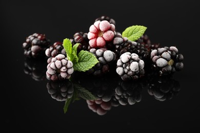 Photo of Many frozen blackberries on black table, closeup
