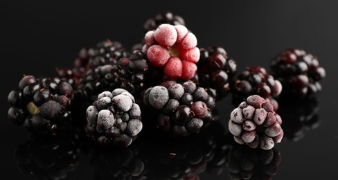 Photo of Many frozen blackberries on black table, closeup
