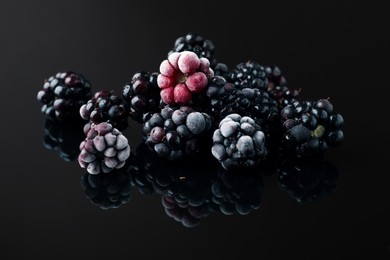 Photo of Many ripe frozen blackberries on black table