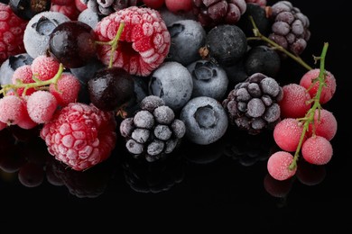 Photo of Many different frozen berries on black table, closeup