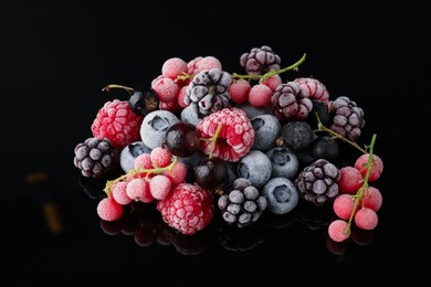 Photo of Many different frozen berries on black table
