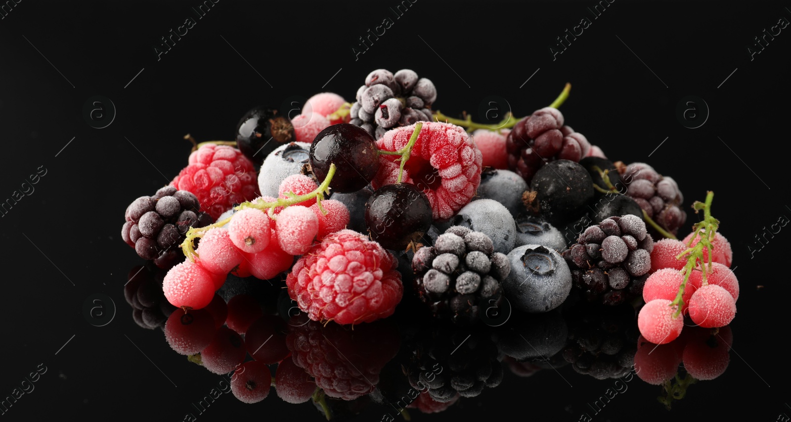 Photo of Many different frozen berries on black table, closeup