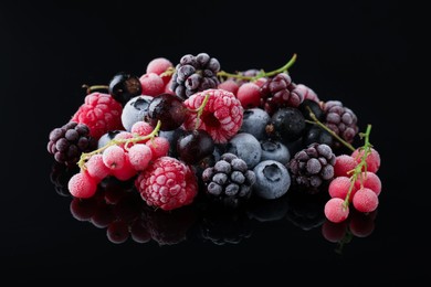 Photo of Many different frozen berries on black table, closeup