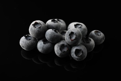 Photo of Many frozen blueberries on black table, closeup