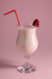 Photo of Tasty raspberry milkshake in glass on pink background
