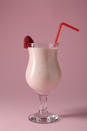 Photo of Tasty raspberry milkshake in glass on pink background
