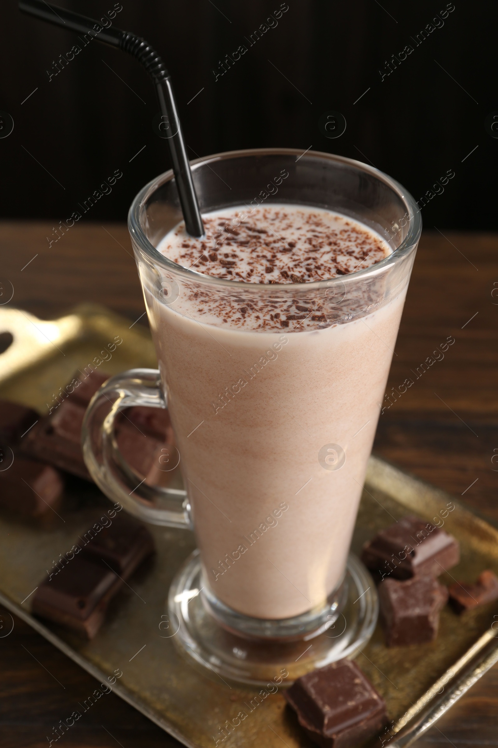 Tasty milkshake in glass and pieces of chocolate on wooden table, closeup Photo of Tasty milkshake in glass and pieces of chocolate on wooden table, closeup