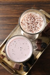 Photo of Different tasty milkshakes in glasses and ingredients on wooden table, top view
