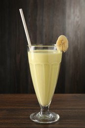 Photo of Tasty banana milkshake in glass on wooden table