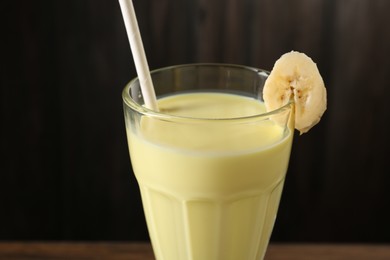 Photo of Tasty banana milkshake in glass on table, closeup